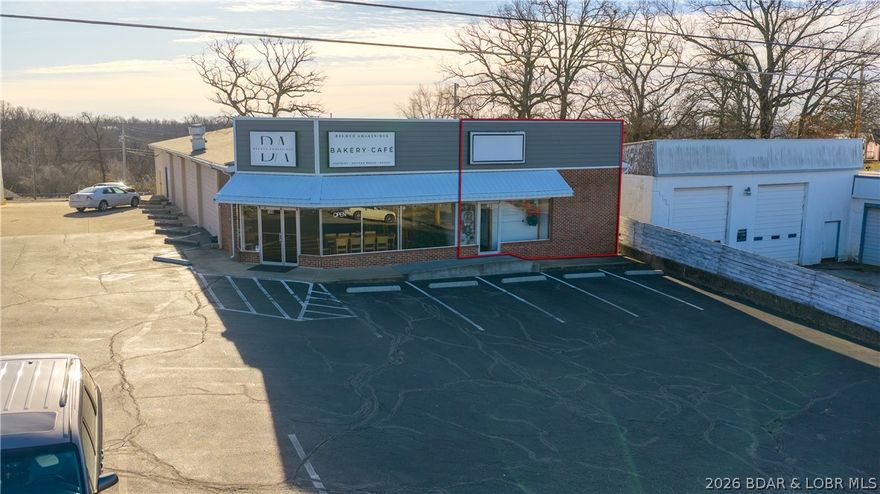 Prime commercial opportunity inside the Camdenton city limits with high-visibility Highway 54 frontage. This 1,675 sq ft unit offers excellent exposure plus dedicated space on the highway billboard for additional advertising visibility. Currently featuring 16 shared parking spaces, with future expansion planned. Seller will escrow $50,000 at closing toward paving the rear lot (pictured), adding an estimated 20–24 additional parking spaces. Interior layout offers maximum flexibility with freestanding walls that can easily be reconfigured or removed to suit a variety of commercial uses. Property includes two bathrooms, HVAC replaced in 2023, and roof replaced in 2019. Tenants in place through August 1, 2026, providing immediate income potential, with leases transitioning to month-to-month thereafter at seller’s discretion. Owner financing available: 10-year term at 7% interest with 30% down, amortized over 20 years, subject to credit approval. Excellent opportunity for investors or owner-users seeking prime highway frontage in the heart of Camdenton.