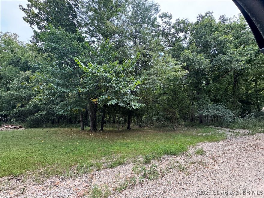 6.94 acres of wooded land just minutes from Laurie, Sunrise Beach and Versailles within walking distance of the Lake of the Ozarks. Build a new home, hunting, camping, exploring, etc.  No HOA.  Public Access, boat ramp and slip rentals less than 10 minutes away.  Buyer to verify all utilities.