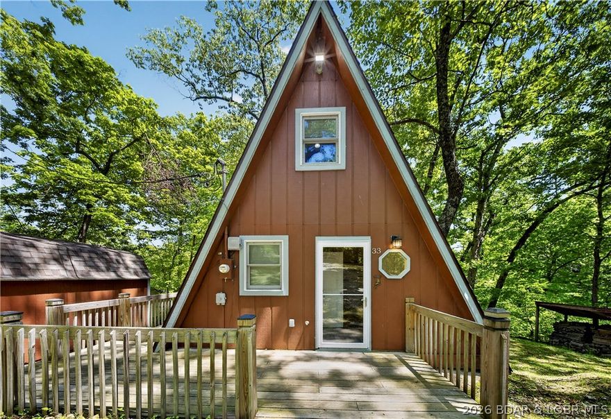 Charming and well-maintained A-frame retreat nestled on two wooded lots totaling 2.06 acres at the 4 MM of Lake of the Ozarks! Tucked away in a peaceful cove with a serene lake view, this cozy getaway offers the perfect blend of privacy, relaxation, and endless potential. Enjoy your mornings or evenings on the screened-in deck overlooking the water, or gather around the spacious fire pit area for unforgettable nights with family and friends. This property includes access to a community dock, pavilion, and swimming area, making it easy to enjoy everything lake life has to offer. Inside, the home is full of warmth and character with plenty of opportunity to make it your own. Whether you are searching for the perfect weekend escape, a full-time lake retreat, or a fantastic investment property with rental potential, this home checks all the boxes. The wooded setting provides a peaceful atmosphere while still being conveniently located near lake attractions by water or land. Bring your vision and transform this adorable A-frame into the ultimate Lake of the Ozarks getaway!
