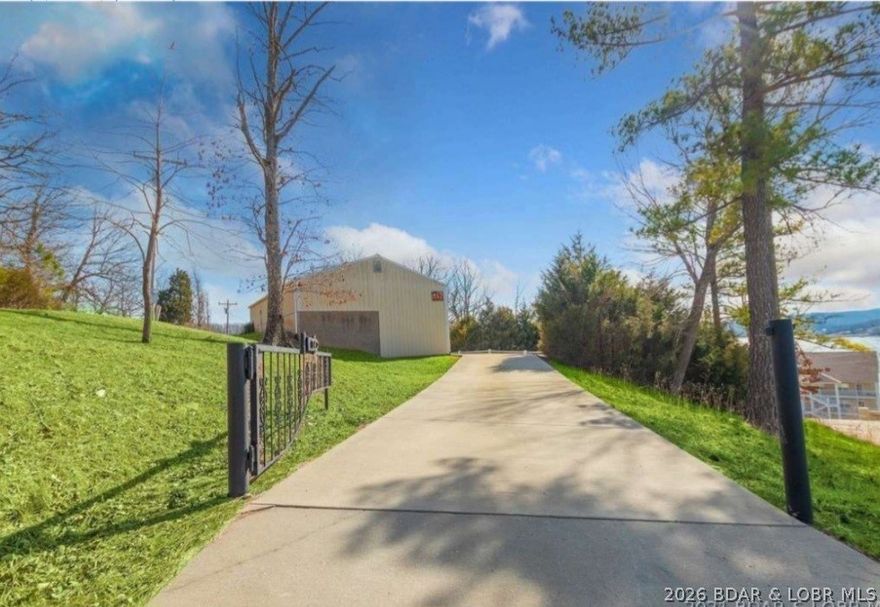 This is a lovely lakeview property that affords a beautiful (seasonal) view of the Lake of the Ozarks, MO. The deck provides a great space for enjoying the sunset & view. Included is a large 1,040 sq ft garage/shop that can park many vehicles or boats. The workshop/shop also has an attached bedroom & a full bathroom- for guests or as an extra rental for income. There is a very nice outdoor firepit play area between the house and the garage, set up for outdoor enjoyment. Inside the cozy home are vaulted wood beams and paneled ceilings, w beautiful wood as an accent. The open floorplan & spacing of the rooms make this 1224 sq ft property seem much bigger. The kitchen is updated plus  3 bedrooms & 2 baths inside the home, one bedrm is non-conforming. A few of the wonderful features are patio doors with built-in blinds, Levolor pleated cloth shades, & windows w/ modern tilting functionality. Nice stainless steel appliances- The crawl space is beautiful with a lighting system-, plus you can stand up in part of it. (Also-available is an upper tier 1/2 acre lot for $12,000- can be purchased separately. No restrictions on the extra lot - could be used for a separate home.- see picts