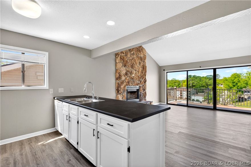 123 Barba Le Lane #3A in Lake Ozark at Robinwood Condos offers a warm and inviting way to enjoy lake life. This top floor, end unit condo features 2 bedrooms, 2 baths, and a bright open layout with vaulted ceilings, a beautiful stone fireplace, and easy access to the deck for relaxing cove and main channel views. Recent updates include new flooring, fresh paint, and updated window and sliding door glass, giving the space a clean and refreshed feel. With a community pool, clubhouse, tennis courts, community dock, 12x28 slip with hoist, and PWC lift, this property is ready for full-time living, weekend escapes, or rental potential.