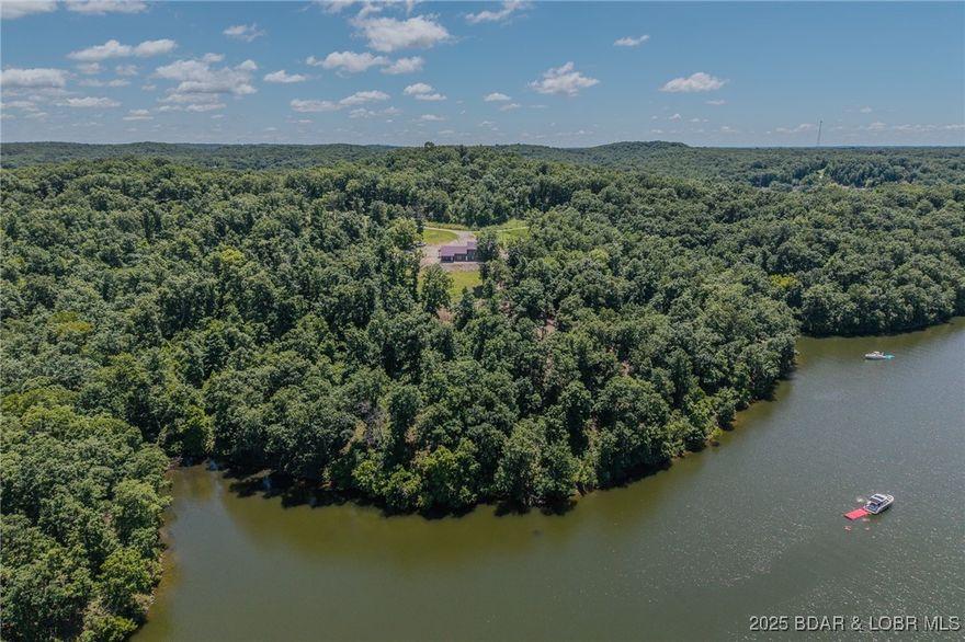 Escape to your own private haven nestled on this spacious property, boasting an impressive 1,415.47' pristine shoreline in a strictly regulated no-wake cove—perfect for kayaking, serene swimming, quality fishing; ensuring calm, peaceful waters ideal for paddling, family fun, wildlife watching, relaxation/recreation; min away from hot spots! A low maint. 3BR, 3BA, sprawling 2,800 sq. ft. shouse: vinyl plank floors, elegant quartz countertops, open floor plan designed for daily enjoyment/ entmt., a mud room-pet wash station, walk-in shower, luxury finishes—ideal as a preserved primary residence, sanctuary, guest retreat, with a personal creative workshop (mini splitter heat/AC), lot's of storage space. Explore options for a subdivision, development or future investment this property offers potential featuring full electric, high speed fiber optic internet, private well-septic, pristine shoreline. DW, stove, MW, Frig. TV stay. Enjoy privacy without sacrificing proximity to restaurants, marinas, golfing, & shops around the lake.  Fulltime occupied must have proof of funds appoint. to see. No drive by. Cameras/video/security in use. Trustee for the trust is a licensed real estate agent.