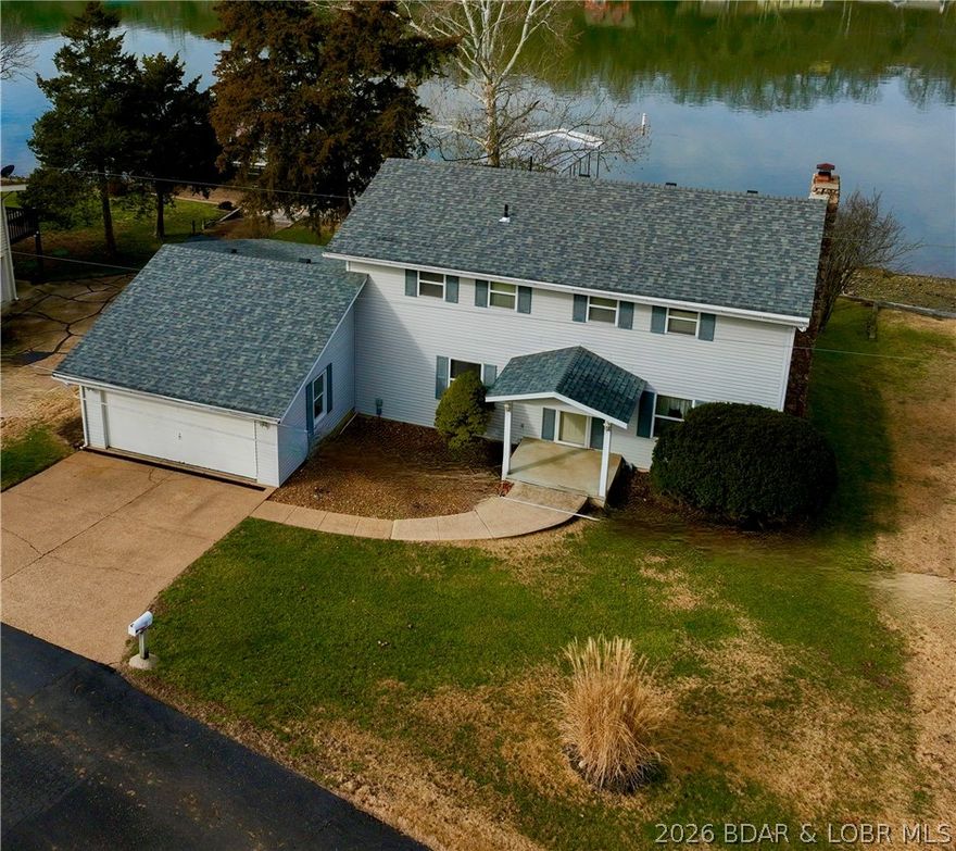 When you are looking for a lawn on the lake (and it is hard to find) this home is for you!  The location does not get any better than this one!  Situated in an established LF community,  this neighborhood boasts of level driveways  into your garages, easy access to the highway, the quiet waters of the Big Niangua and being only a stone's throw to Kinderhook and Lake Valley Golf Courses. Haha Tonka is also a short drive from this home; close enough to make the stairs a part of your work out regimen in the most beautiful state park in Missouri. This spacious family home featuring 4 bedrooms and plenty of bathrooms is the ideal retreat for hosting guests or raising a family. An open kitchen and dining room space leave plenty of room for a formal dining room or  hearth room right off of your kitchen. An enclosed sun room that spans the lakeside of the home create a space that is open and bright.  The level backyard is the hallmark of this property where there is abundant room for a large fire pit, outdoor kitchen, and the perfect place to host a bean bag tournament right in your back yard that is level and invites outdoor entertaining spaces right at the waters edge.