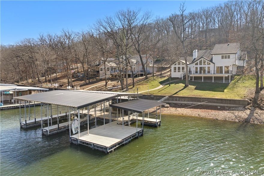 Experience the ultimate dream with this modern oasis at the 11MM of Lake of the Ozarks! This completely renovated 3BR/2.5BA lakefront masterpiece is essentially a brand-new home, blending sleek contemporary design with the natural beauty of a highly desirable Four Seasons. The expansive living area features a gas fireplace and expansive windows that flood the home with light while framing breathtaking views. A chef’s dream, the gourmet kitchen boasts custom cabinetry, stainless steel appliances, and a large center island. The master suite is a true sanctuary, offering a massive walk-in closet with built-ins and a spa-like double shower. Elite Waterfront Living with New 3-well concrete Trico dock (12x28, 12x26, 12x12) with swim platform and dock locker. Super gentle walk-out to 105ft of lake frontage with cove protection. Expansive Trek decking perfect for sunset dining and relaxation. Located in a highly desirable area, this home offers the ultimate lakefront living experience with access to all the amenities that Four Seasons has to offer! This home checks every box for luxury lakefront living with zero compromise.