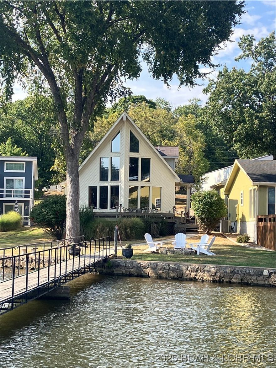 **PRICE REDUCED**   <<<LEVEL LEVEL LAKEFRONT LOT>>>  A wall of windows and vaulted ceilings. Main level living! **SELLER MOTIVATED** Big view from this COVE location looking out to the main channel. Main level living includes - Primary bedroom, kitchen 
, living room, laundry, and full bath, along with garage entrance are all on the main level! A large guest bedroom and loft bedroom located on the second level with a full bath. New granite counters in the kitchen, newer stainless steel appliances, newer light fixtures and ceiling fans. Two car attached garage. Enjoy the sun coming up in the mornings and shade on the large deck in the evening. Large dock included. Bring "ALL" Offers!