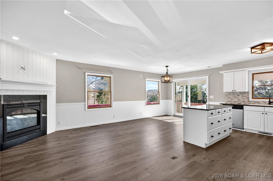 Thoughtfully updated two-story home in a prime location next to Old Kinderhook Golf Course, featuring scenic views of the Lake of the Ozarks. Updated two-story home ideally located next to Old Kinderhook Golf Course, offering beautiful views of the Lake of the Ozarks. The main level features an open-concept layout with three bedrooms and two-and-a-half baths, highlighted by new LVP flooring, granite countertops, updated light fixtures, and a newly installed gas fireplace. The walkout lower level includes an oversized bedroom, full bath, utility/laundry room, and a spacious family room that opens to an almost level yard. A detached two-car garage adds convenience. Recent upgrades include a new HVAC system, roof, flooring, two fireplaces, new appliances, and more. A fantastic home in a prime location close to all the lake amenities.