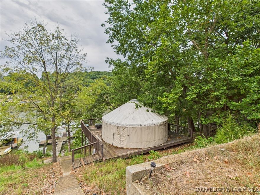 No HOA. No zoning restrictions. No cookie-cutter limitations. This is the kind of freedom that’s getting harder to find at Lake of the Ozarks—especially on true lakefront.

Set on 75 feet of waterfront at the 70MM, this property gives you options most others don’t. Whether you’re looking for a unique weekend setup, a short-term rental project, or a future build site, the groundwork is already in place with electricity on site, a yurt-style structure on a permanent block foundation, and a covered 2-well dock with swim platform ready to use. Concrete stairs lead you straight to the water, so you can enjoy it from day one.

This property isn’t for everyone—and that’s exactly the point. It currently operates without a well or septic, making it ideal for a buyer who sees the upside. With those improvements in place, a local property manager has projected nearly $27,000/year in short-term rental potential, turning this into a strong value-add opportunity.

Lakefront under $80K with this level of flexibility is rare. If you’ve been waiting for something you can actually make your own—and build equity into—this is it.