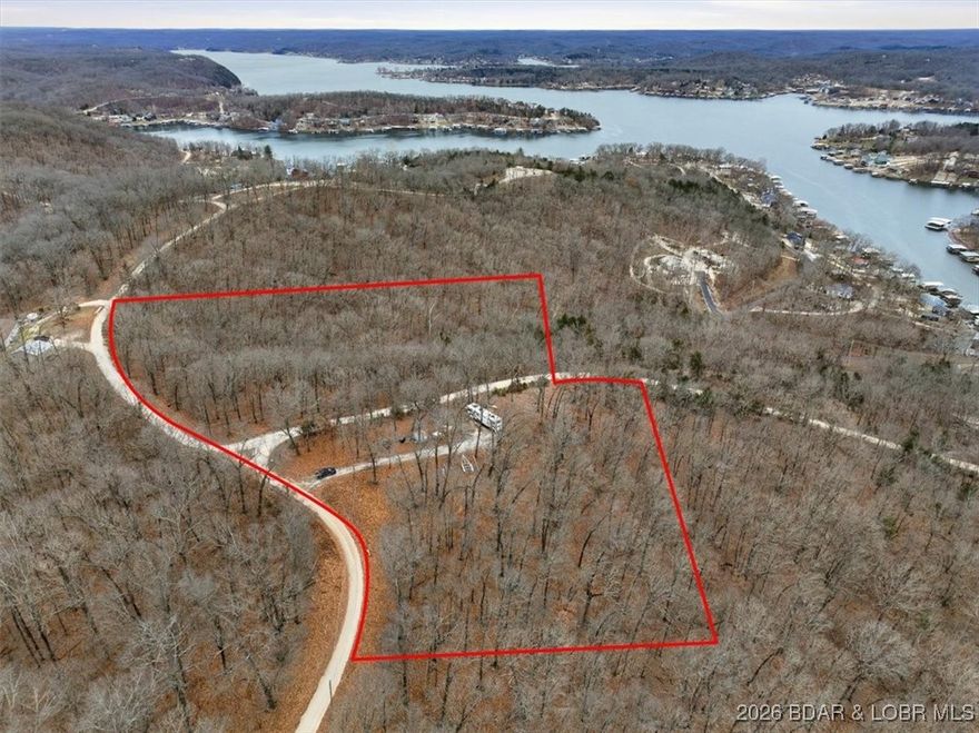 Situated at the top of Upper Hill Drive, this lot provides spectacular elevated views overlooking the 44MM and abundant woodland surroundings — a serene setting that promises peace and tranquility. Enjoy plenty of room to roam with wildlife, great camping spots, and scenic views year-round. This remarkable property presents an ideal canvas for your custom home, or RV retreat close to Lakefront Restaurants and Entertainment like Big Dicks, Red Fox, and near Ozark International Raceway and the town of Laurie. With electricity, your own private deep well, and private septic on the property, this is the perfect turnkey lot with NO RESTRICTIONS!