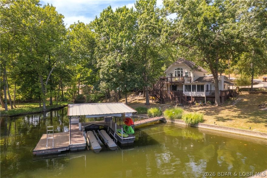 Discover a rare gem with this exceptional, level waterfront lot on Lake Ozark. Finding a lot like this is truly a challenge. This home underwent a complete remodel in 2023, featuring new cabinets, flooring, countertops, stainless-steel appliances, decks and more. Enjoy the open, airy feel created by a vaulted ceiling and an abundance of windows. The home is tastefully decorated and ready for you to enjoy. It comes completely turnkey, including the dock and a lift. The spacious 4-bedroom, 3-bathroom layout is perfect for the whole family, both inside and out. The location is unparalleled—tucked away in a protected cove at the 1-mile marker. Being the last dock in the cove, you'll love the peaceful and private setting. Despite the calm environment, you're only a few miles away from all the lake's main attractions. Whether you're looking for a personal retreat or an investment opportunity, this property is a fantastic choice. It's currently a rental on Airbnb and VRBO, offering a great way to offset costs while you're not there.
