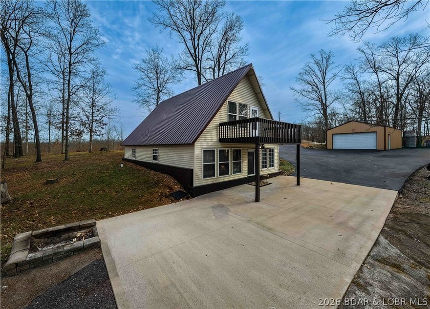 Discover this move in ready, A-Frame retreat @ Lake of the Ozarks positioned on a private, wooded setting just one mile off blacktop. This 4-bedroom, 1.5-bath home blends rustic charm w/ tiled floors, oak cabinets, stainless appliances including a propane gas cookstove plus ample storage & sleeping space for 8+ guests making it an ideal full-time residence, weekend escape, or high-performing vacation renta/fish campl. No-step entry adds everyday ease to all main living areas while upper-level primary suite features vaulted ceilings & private deck overlooking the Missouri outdoors where one can see frequent wildlife sightings—deer, turkey, & birds. Or gather around the fire pit & concrete patio after a day on the water. The large detached shop/man cave offers room for vehicles, a fishing boat, ATVs, and all your gear—perfect for hosting unforgettable fish fry weekends. Located just minutes from Wigwam Boat ramps or Patriots Marina, this property is ideal for anglers & lake lovers alike. No rental restrictions, strong short-term rental potential, metal roof, ample parking & peaceful surroundings, this turnkey property is the perfect Ozarks getaway & investment opportunity awaits.