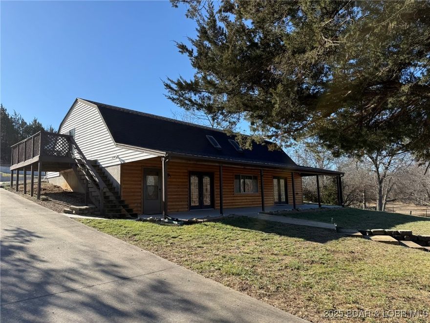 Waterfront living at its finest on Lake of the Ozarks! Nestled in a quiet no-wake cove, with its own boat ramp & generous waterfrontage, you’ll enjoy elbow room on the water plus the opportunity to expand if desired. The home features a semi-open floorplan designed for convenience, with all main-level living including the kitchen, dining, living room, laundry, master suite, and a second bedroom. Upstairs, two spacious bedrooms share a Jack-and-Jill bath, each with its own private deck overlooking the lake. Step outside to a large, covered patio with sweeping views of your private two-well dock, connected by a concrete sidewalk for easy access. The well-manicured lawn reflects pride of ownership, ample parking ensures room for friends and family. Detached shop provides excellent storage for boats, lake toys, or hobbies. Set on over 7 acres, with approximately 5.5 acres ready for a walking trail or the addition of another shop, this property offers endless possibilities. Whether you’re seeking a full-time residence or a weekend retreat, this lakefront home delivers the space, amenities & lifestyle you’ve been searching for.