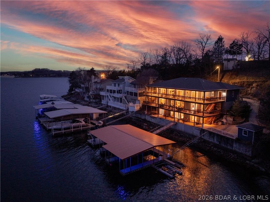 Luxury lakefront home for sale at the highly desirable 1 Mile Marker of Lake of the Ozarks. This turn-key 6-bedroom waterfront property spans three levels of beautifully updated living space and operates as a top-performing vacation rental. Enjoy panoramic main-channel views with the added benefit of cove protection—ideal for boating, swimming, and family fun. The home features three levels of living, two full kitchens, a built-in dance floor complete with entertainment lighting, and wall-to-wall lake-facing windows. The primary suite offers stunning water views, while multiple living areas and guest suites make the home perfect for large groups. Outdoor living shines with expansive decks, patios, and an easy walk to the private 3-well dock. A rare 4-car garage and flat parking provide unmatched convenience. Whether you're seeking a luxury lake house, a high-income vacation rental investment, or a premier Lake of the Ozarks retreat, this property delivers exceptional value, location, and waterfront lifestyle.