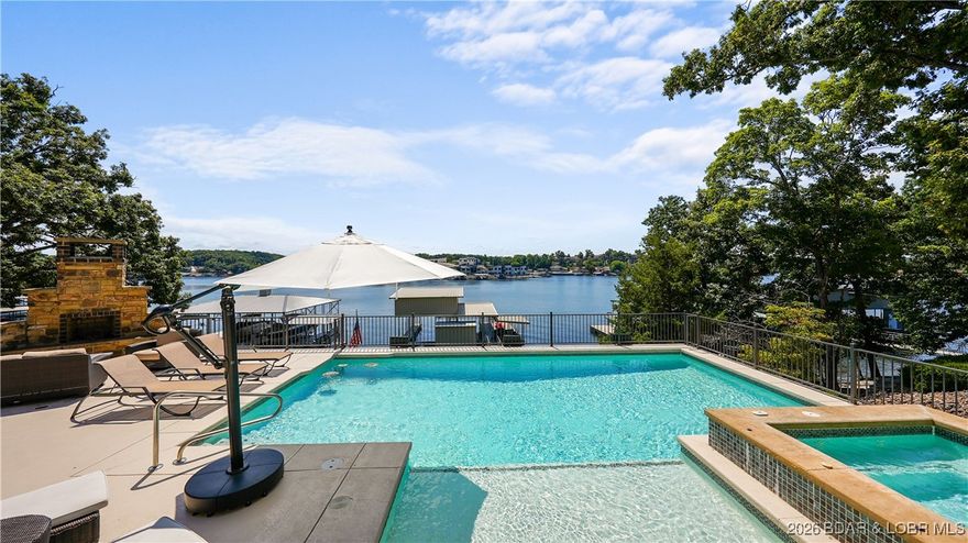 Outdoor living defines this turnkey lakefront home in Porto Cima at Lake of the Ozarks. Located Chimney Cove with south by southwest exposure, this remodeled 4,132 sq ft that is designed for entertaining! The exterior living spaces include a heated saltwater pool and spa, outdoor fireplace, and a covered lakeside kitchen with grill, sink, bar seating, TV, and cooling misters. Multiple decks create defined lounging and dining zones overlooking the water. A gentle driveway offers easy access and abundant parking, enhanced by mature landscaping that provides privacy and strong curb appeal. A cart path leads to a private dock featuring two slips up to 16x46, two PWC lifts, a dock kitchen and outdoor shower, ideal for full lake days and effortless hosting. Inside, the open floor plan showcases Wolf and Sub Zero appliances, a large stone island, tray ceilings, and lake views from both the main living areas and the primary suite. Located within Porto Cima, residents enjoy the Jack Nicklaus Signature Golf Course, clubhouse and Pickle Ball Courts. Offered fully furnished with custom curated décor and designer furnishings throughout and true resort style living
