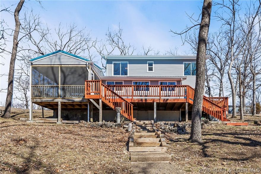 Newer metal roof, gutters & downspouts, newer vinyl siding, newer LVP flooring, beautifully updated kitchen  with stainless steel
appliances, custom cabinetry, and quartz countertops. Nothing to do except enjoy the big lake view of the 7MM of Lake of the Ozarks through the new windows. Lots of privacy and elbow room and entertaining areas - including a composite martini deck, patio over the boat garage, fire pit, large screened in deck and large open deck for the sun-lovers.Cabinets in the oversized 2-car garage/workshop stay. There's room to build more out buildings. Great location by road or water, close to restaurants, golf course, movie theater and shopping.