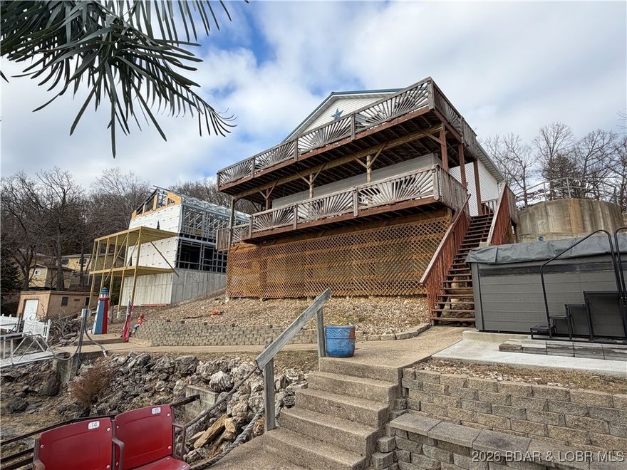 Welcome to this charming, light-filled lakefront home offering breathtaking views of Lake of the Ozarks & unforgettable sunsets. Just step outside onto the spacious decks to soak in the serene lakeside ambiance... perfect for entertaining family, friends and guests. Main Level features Open floorplan, main level living, a spacious kitchen w/plenty of cabinets & overhead lighting , Vaulted Ceiling, Nice size primary suite w/adjoining  bath complete with double vanity, oversized mirror & walk in shower w/frameless sliding glass doors and a second bedroom. Lower level features a Large Family Room, 3rd bedroom, versatile oversized bonus space with endless possibilities-could easily be converted into a 4th bedroom, bathroom w/lighted mirror & large storage area. Venture down to the lakefront & enjoy the Swim Spa (perfect year round ), relax on the martini deck w/bar area, Fish right from your dock or Launch your boat and head straight out to the lake! Located close to Waterfront Entertainment- Let's Go! PLUS Tons of parking w/room to add garage (entry door already in place) & 2 second tier lots included. INVESTORS - Perfect Property for Vacation Rental!