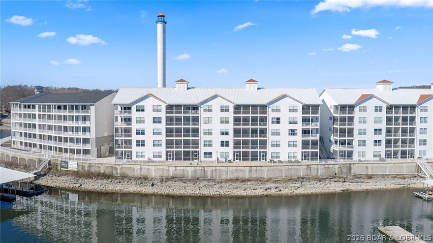 Discover the best of Lake of the Ozarks at Isla Del Sol. Located at the 4MM, this remarkable 3-bedroom, 2-bathroom turnkey condo offers a "million-dollar view" stretching for miles. This lower-level, walk-out unit combines luxury and convenience, featuring elevator & handicapped access and a coveted 12'x32' boat slip in a prime cove-side location. The exquisite lakeside master suite pampers you with a spacious walk-in closet, dual vanities, and a lavish walk-in shower. Relax on the screened-in back porch, where you can take in unique views of the iconic Bagnell Dam and the scenic main channel. Life at Isla Del Sol feels like a permanent vacation. The community offers top-tier amenities, including a stunning zero-entry pool with water fountains, professional BBQ grills, and two inviting gas fire pits for evening gatherings. Whether you are looking for a full-time residence or a high-end getaway, this condo delivers the ultimate lake lifestyle.