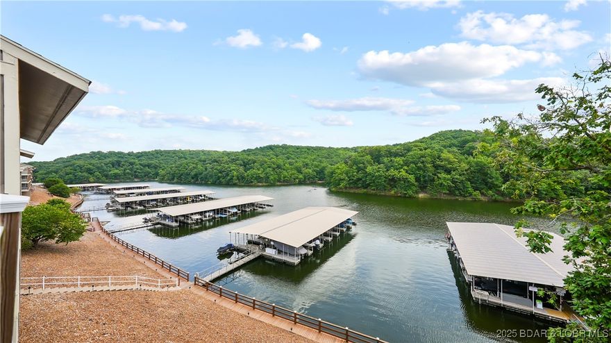 Top floor, vaulted ceiling, panoramic views of Lake of the Ozarks State Park that are permanent because that shoreline will never be developed. Unit B11 at Lazy Days on the 3 mile marker of the Grand Glaize arm in Osage Beach is a fully furnished, updated 2-bedroom 2-bath condo with a 10x24 boat slip included, vacation rental opportunity and a price of $265,000 that is hard to argue with. Updated in 2020 with new vanities, fixtures, and stylish interior doors, this condo is completely turn-key. Lazy Days is one of the most well managed complexes on Lake of the Ozarks and the association budgets reserves properly so nothing catches owners off guard. The complex qualifies for conventional financing, which keeps the buyer pool strong and supports long term value. Owners and guests can swim directly off the no wake cove dock, two pools, two playgrounds, a grilling pavilion, an onsite ice machine, and boat and trailer parking round out a complex that is genuinely easy to own. The Lake of the Ozarks Shootout finish line is visible right from the property, and the nearly $500 million Oasis at Lakeport resort is just down the road.