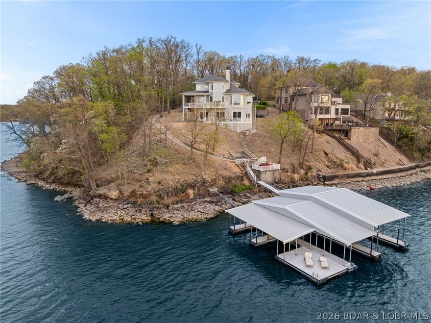 Experience elevated lakefront living in the exclusive community of Porta Cima with this beautifully reimagined 5-bedroom, 4-bath residence. Offered fully furnished with designer-selected Ashley Signature pieces, this turnkey home blends style, comfort, and functionality—ideal as a full-time residence, luxury getaway, or income-producing investment. Take in sweeping main channel views at the 14 MM from the expansive deck or relax year-round in the inviting screened porch. The upper-level primary suite offers a private retreat with a lofted design, spa-like jetted tub, and an oversized walk-in closet. Inside, walls of windows flood the home with natural light while showcasing breathtaking lake views. The walkout lower level is built for entertaining, featuring a spacious second living area and wet bar - perfect for hosting guests. An oversized 3-car garage provides ample room for vehicles and lake essentials. Thoughtfully updated and impeccably maintained, this property delivers the perfect balance of luxury, space, and lakefront lifestyle.