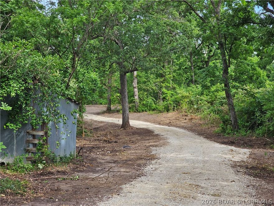 Discover your dream property on this secluded 3.3-acre parcel, perfectly situated with blacktop road frontage on Hwy Y and Beacon Rd. With 2 ESTABLISHED entrances. Located directly across from the prestigious Vienna Woods Subdivision, this unrestricted lot offers endless possibilities. A newly built driveway winds through mature timber to a cleared house site, offering privacy and room for a large shop or additional structures. Dual road frontage (Hwy Y and Beacon Rd.) allows for a through-driveway, maximizing convenience and development options. Clear a few more trees for a stunning view of a shared pond, enhancing the property’s charm. No Restrictions: Build your dream home, shop, or recreational retreat with complete freedom. Less than 2 miles from Eldon, a thriving community with excellent job opportunities and a top-rated school district.