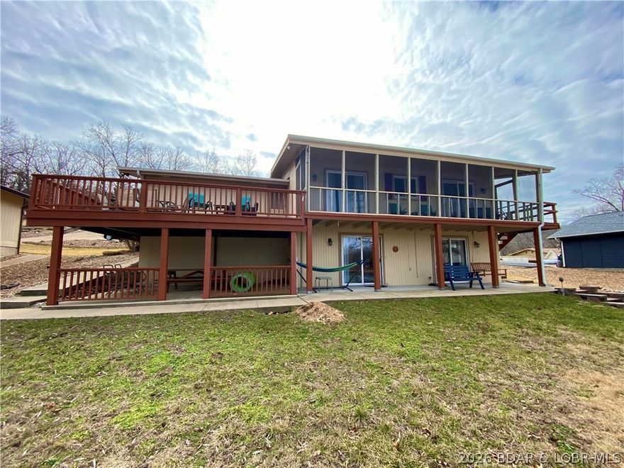 Turn-key lakefront opportunity in Osage Beach with 63’ of waterfront and a well dock included! Whether you’re searching for a proven vacation rental investment or the perfect family lake retreat, this 4BR/2BA home checks every box. Located in a large cove at the 23 mile marker, enjoy gorgeous sunset views, calm water, and easy access by land or lake. Gentle topography with only 14 steps to the dock and an easy drive to the front door make this property ideal for all ages. Inside features vaulted ceilings, warm wood accents, and an open main-level living layout designed for lake life. Expansive, freshly painted deck and patio space plus a screened-in porch with new flooring create the ultimate setting for entertaining and relaxing. Attached garage for added convenience. Offered fully furnished and ready for immediate enjoyment or rental income from day one, plus a new engineered septic system scheduled for installation beginning 2/26 (weather permitting) for added long-term value and peace of mind. Conveniently located near top waterfront restaurants, shopping, and entertainment—this is lake living done right.