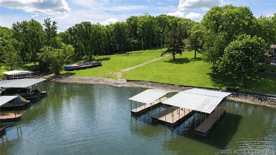 Discover the perfect opportunity to build your dream home at Lake of the Ozarks! This rare flat waterfront lot is located in Camdenton, just off Old Hwy 5 near the Niangua Bridge, and close to popular attractions like the Ozarks Amphitheater and Bridal Cave.
This property truly checks all the boxes—featuring 323 feet of shoreline with over 120 feet of usable lakefront in a protected cove setting. A 2-well dock and private boat ramp are already in place, making it easy to start enjoying lake life right away. Even better, there’s no HOA to limit your vision.
The current owners have already secured approval for a 5-well dock, and house plans are available—saving you time and effort in the building process. Electric is on-site, while a well and septic system will need to be installed.
Flat, cleared waterfront lots like this are hard to come by—don’t miss your chance to own a prime piece of Lake of the Ozarks and create the home you’ve always wanted.