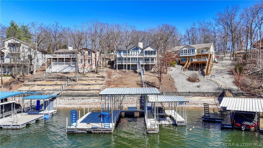 Lakefront living with style, space, and serious upgrades in Four Seasons. This 3,100+ s.f. 5 bed, 3.5 bath home is perfectly positioned on a wide channel with incredible views and easy lake access. Designed for both entertaining and everyday comfort, the home features a climate-controlled sunporch for year round use, two expansive lakefront decks, and a concrete cruiser dock built for full-size boating. Nearly $170,000 in luxury updates elevate this property, including custom bunk room additions, all bathrooms renovated & enlarged,(new en suite), new lighting and hardware throughout, updated flooring, quartz countertops, interior paint, added walk-in closet, wet bar, new water heater, and extensive dock improvements -SEE ALL ON LISTING ATTCHMTS. The layout offers generous sleeping space, multiple gathering areas, and seamless indoor-outdoor flow for enjoying the Lake year-round. Whether you’re hosting family weekends or relaxing with sunset views after a day on the water, this home delivers comfort, function, and polish in one of the Lake’s most established communities. A rare opportunity for buyers seeking a move-in-ready lakefront home with quality upgrades already done.