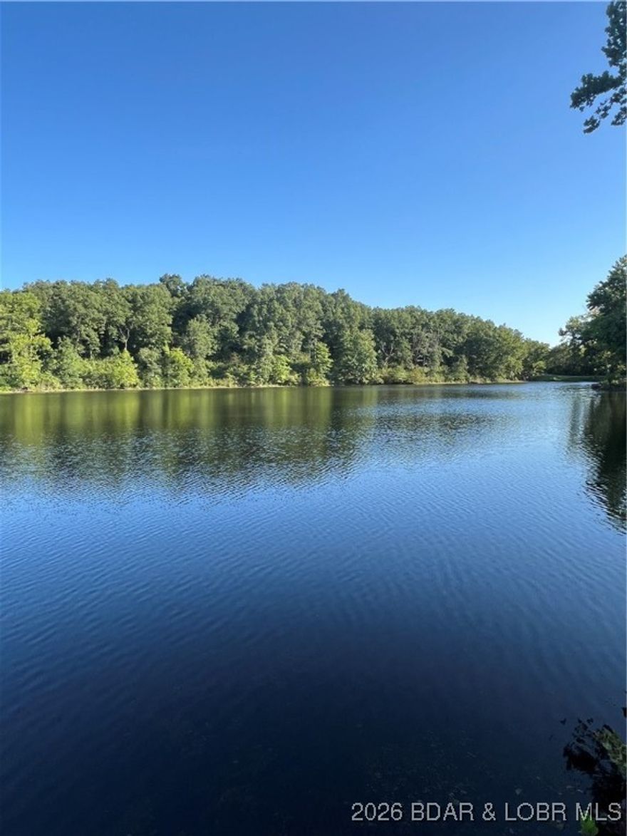 Wonderful chance to own lakeview property on private spring fed lake. Canoe, fish, or just enjoy the view. The road is between this property and the actual lakefront. Lakefront belongs to the resort corp and access to the lake is arranged thru them. You will also be close to public access to Lake of the Ozarks and a conservation area just south of the resort. Buffalo Creek Conservation Area has hiking trails and a conservation grounds. This would be great for a vacation cabin or a full time home if you love the quiet and peaceful life. Well worth taking a look.