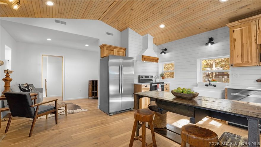 Step into this fully remodeled cottage in the heart of Osage Beach, where timeless charm meets modern craftsmanship. Originally built in the 1940s, this home has been brought beautifully back to life with incredible attention to detail. Featuring 3 bedrooms and 2 full bathrooms, it’s ideal as a full-time residence, weekend retreat, or investment property. The stunning custom kitchen showcases an antique island, pine ceilings, and rich finishes throughout. A rock surround electric fireplace creates the perfect touch of ambiance, while easy access to the deck creates the perfect entertainment location while taking in the lake views. The main level master bedroom features a rock wall with built in bookshelves and a large closet. The lower level offers two bedrooms (one ideal as a living room), a full bath, and laundry. Outside, the stone patio is a serene spot to unwind. Enjoy being within walking distance to Panera Bread, Andy’s Frozen Custard, Sergio’s, and more. This “like new” home is truly one of a kind—schedule your showing today!