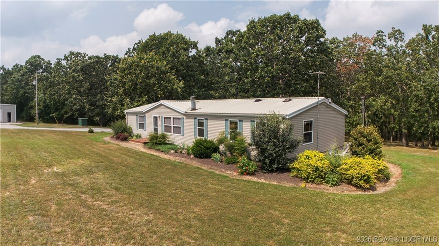 This meticulously maintained 3BD,2BA home sits quietly at the end of a long driveway on 74 beautiful acres. The care and attention given to this property are evident at every turn featuring a newer roof & gutters, newer windows & doors, dishwasher, water heater, along with carpet and laminate flooring throughout. A wood-burning fireplace anchors the living room. The spacious primary bedroom includes additional space ideal for an office, nursery, or sitting area. Step outside onto the expansive 12’x33’ deck-an ideal spot to relax and enjoy abundant wildlife. A Shelter Wood-burning outdoor furnace provides an efficient alternate heat source. Approx. 30 acres are used for hay production with the remaining in timber, offering excellent versatility for farming or recreation. A 30’x40’ insulated steel building with concrete floors, plus a former garage converted into pens for chickens and rabbits. The beautifully landscaped yard offers plenty of room for playsets, horseshoe pits, or open green space just as it is. Garden enthusiasts will appreciate the 14’x32’ greenhouse, ready for all your growing needs. With COMO fiber internet available at the road, this property truly has it all!