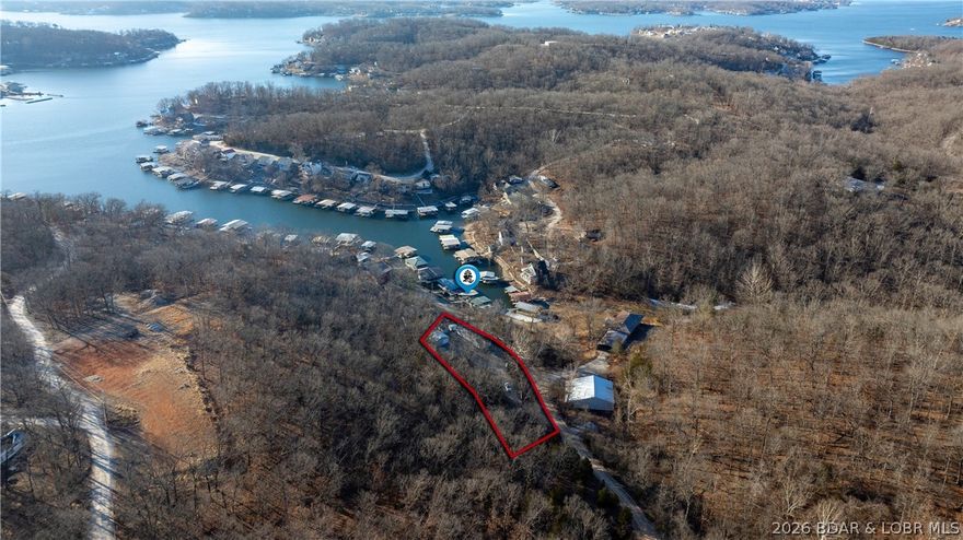 CALLING ALL WEEKEND WARRIORS, BOATERS, AND LAKE-LIFE DREAMERS! Tucked just off the 5MM in protected Lick Branch Cove, this lakefront getaway delivers the perfect blend of privacy, space, and easy water access. Enjoy calm cove protection with quick access to the open water of Lake of the Ozarks. This 3-bedroom, 1.5-bath home is built for relaxed weekends and hosting friends, with plenty of room to gather inside and out. The back patio features controllable lighting—perfect for evening entertaining after a full day on the lake. Just steps away, the private dock offers updated flow-through decking, a 10x24 slip, 6,000 lb lift, and storage, making lake days effortless.(Additional Parcel with dock is included) Situated on a rare .60-acre lot with gentle topography, you’ll also find two storage sheds and a 24x24 wired garage for all your lake toys and gear. Being sold mostly turn-key, this property is ready to enjoy from day one and offers incredible potential as a weekend retreat, full-time home, or rental investment. Space, privacy, and dock-right-there convenience—this is the kind of lake property people hold onto. Schedule your showing before it’s gone.