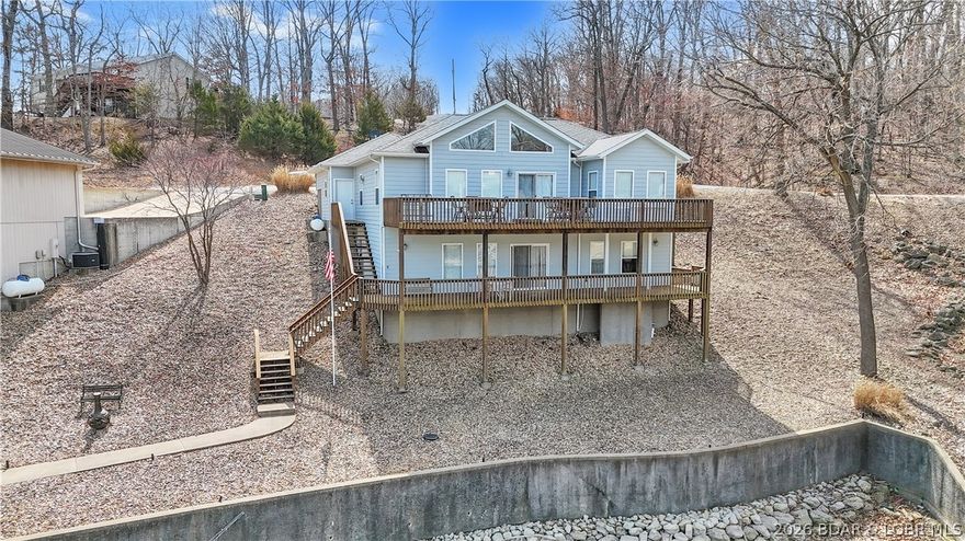 Enjoy the ultimate Lake of the Ozarks lifestyle in this beautiful 2,400 sq. ft. 4 bedrooms & 3 bath home in the desirable Calvert development. Perfectly situated near the 26-mile marker, you’re just minutes from shopping, golf, and dining, yet tucked away with peaceful cove view & deep-water access. The main level features a bright, open floor plan with a spacious living area, a large dining space, & a modern kitchen with quartz countertops, stainless steel appliances, bar seating, pantry, and walkout to an upper deck—ideal for entertaining or enjoying your morning coffee. Luxury vinyl flooring adds a fresh, contemporary touch. The lower level offers a second living area, wet bar, 2-bedrooms and bath, & walkout access to a 2-well dock, complete with a dock locker, double PWC hoist, and boat hoist—perfect for boating, swimming, or relaxing lakeside. Additional highlights include a gentle double lot, & a 2-car garage with cabinets for extra storage. Ample parking. This home has been thoughtfully updated finishes, this home combines comfort, convenience, & lakeside luxury. Don’t miss this rare opportunity to live your lake dreams—schedule your showing today!