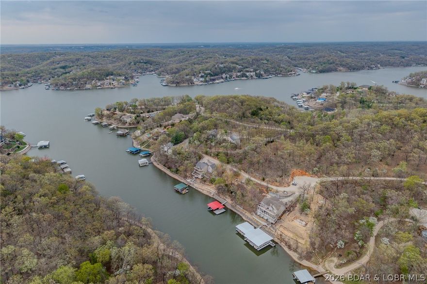 This is THE building spot you've been looking for. Location Location Location! 31MM, Four Corners Area, Within 5 minutes of The Fish and Company and Larry's on the Lake, 92 feet of YEAR ROUND DEEP WATER, Cove Protection, Small Subdivision with NO HOA restrictions, close to your favorite waterfront hotspots and only 7 minutes from the square in Camdenton---check-check-check! This lot is already set up and ready for your dream home. Shared well, shared sewer and electric already in place. This is the perfect spot for a larger home or your dream home with a lakefront pool! Survey on file, permitted concrete seawall and permitted rip rap in place. This is one of the very few lakefront lots listed near the 31MM and the Four Corners area of the lake-check it out now! Dock permit envelope and dimensions available-DOCK NO LONGER ON SITE.