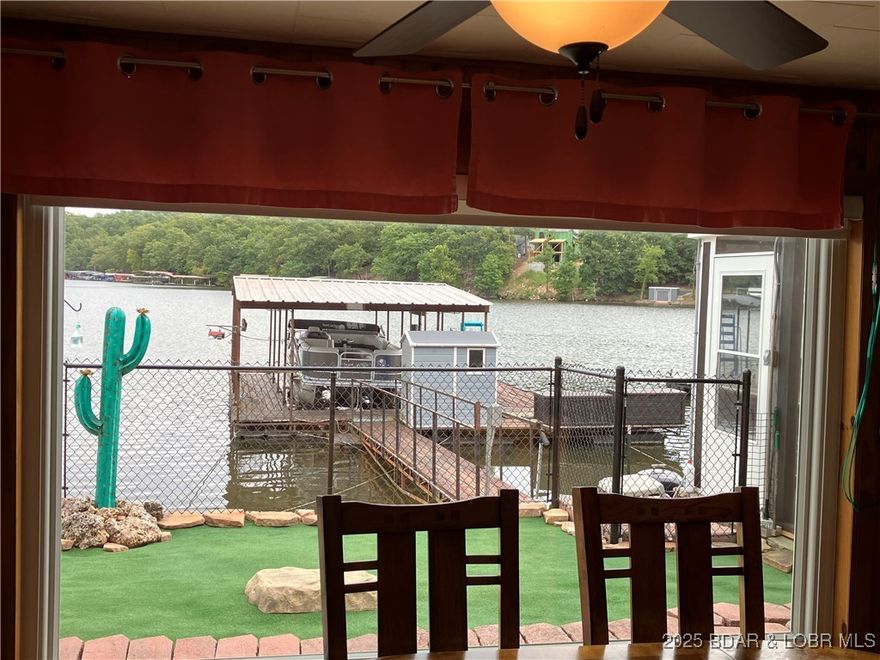 ***Huge PRICE REDUCTION*** Rare find  "Level"  Lakefront home sits right on the water! *** SELLER MOTIVATED*** Just "5" steps to your dock. **Huge over sized 2 car garage** with unfinished loft area above could be finished into a good sized apartment. Tons of storage. Large kitchen with tons of cabinets and counter top space, includes newer SS appliances. Newer windows throughout. Large screened in porch with view of cove. Minimal steps to dock. No grass to mow. Fenced in area for pets or little ones. Large wide cove with views of main channel. Close to marinas and nearby lakeside restaurants. 3rd Bedroom is Non conforming, could also be used for 2nd living room. Please ***BRING ALL OFFERS***