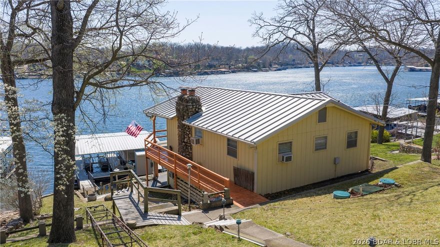 Easy lake living starts here. This classic 3BR / 2BA lakefront home sits at the 10 Mile Marker on a gentle lot and offers the best of both worlds—big 6+ mile views down the lake plus the cove protection you want. With ideal southeastern exposure, you’ll enjoy bright mornings and cooler afternoons all season long. The home has been well cared for, featuring a standing seam metal roof and exterior siding in excellent condition. There’s also an oversized 2-car garage with a workshop area, perfect for storing lake toys and tackling projects. Inside, the home has a clean, timeless feel and is a true blank canvas ready for your updates and personal touch. Recent improvements include updated dock electrical and a refreshed main-level bath and shower. Down at the water, you’ll find a great 2-well dock complete with two poly-lift boat lifts, making it easy to get out on the lake. Tons of level parking right off the road adds everyday convenience. Whether you’re looking for a private getaway or a solid investment for nightly rentals, this one checks a lot of boxes at a great price point.