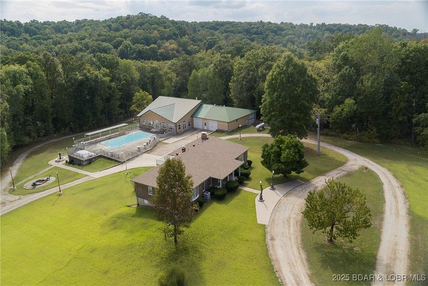 Unlock the unlimited potential of 241 wooded acres close to Lake of the Ozarks and Ozark International Speedway. The 5400 sq. ft. pavilion has potential for weddings, special events, etc. and has 9 motel units on the lower level (3 are finished). The grounds include 12 drive-thru RV sites with hook-up and 10 without hook-up. There are additional tent/camp sites, ATV and hiking trails, 2 live creeks. There's a 5,000 sq. ft. brick owners home, with 3 bedrooms, 3 baths, office, wood parquet flooring, large in ground swimming pool, 20 person hot tub, fire pit, detached garage/workshop. This would make a greathunting retreat, lots of deer and turkeys. The possibilities are endless.