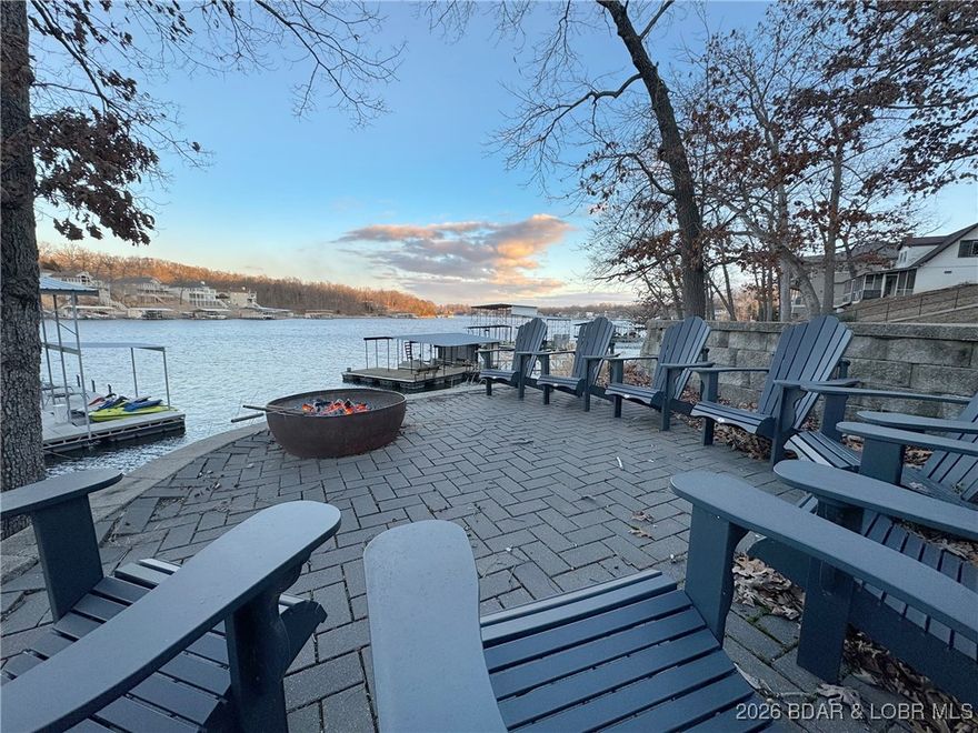 Show-stopping waterfront retreat on 8mm w/spectacular lake views! Impressive work of craftsmanship features reclaimed wood + shipyard beams, custom lighting, & heated floors. This stately, open-concept creates a tranquil feel of rustic sophistication - completely furnished. Striking architectural impact, designed for resort-style living or high-end short term rental earning $2k per night (proven $150k+ yearly), this sprawling estate is built to please a crowd. Gourmet chef’s kitchen boasts state-of-the-art commercial-grade stainless steel appliances w/ impressive 17-ft custom island. Sleeping 25+, this iconic estate offers 6 unique king bedrms, each w/full spa-style baths, incl 2 primary suites w/sitting areas + covered decks. Addl Bunkhouse sleeps 11.  Epic game room incl professional-grade pool table & shuffleboard for endless fun. Outdoors, enjoy a massive screened-in patio w/ locker-room-style bathroom - quick outdoor access for swimmers & boaters. Above 2-car garage/workshop - luxury 2-bdrm apartment + loft bed- sleeps 6, perfect for rental. Metal Roof. Deep water, 2-bay concrete cruiser dock + 2PWC lifts. Unparalleled waterfront sanctuary that defines upscale vacation living.