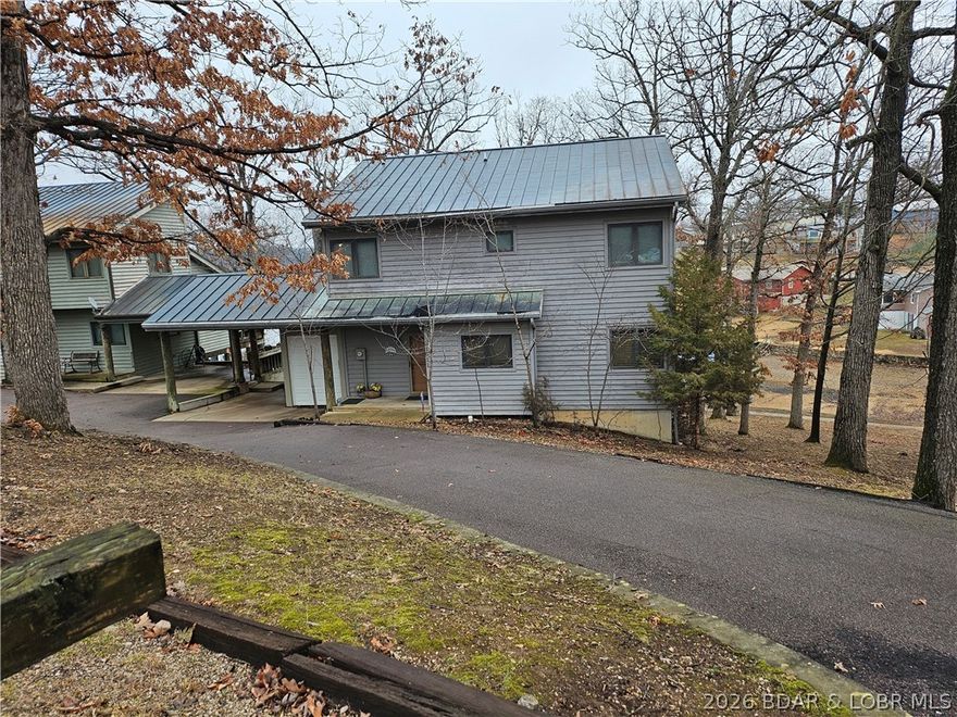 Carefree lake living with this stand alone townhouse located on the Gravois Arm.  The only connecting section to the neighboring unit  is the open carport. No connecting wall with the living spaces. It's like having your own private residence!  The main level consists of a 2-story great room with a wood burning fireplace, a large kitchen with plenty of counter space and cabinets, all appliances included, small eat-at counter in kitchen, a dining area, half-bath and laundry/utility room. The upper level has a master bedroom with a bath and 2 guest bedrooms with a hall full bath in between them.  The walkway overlooks the great room. There is a carport for your vehicle and a small storage shed with a garage door for your lake toys and other items. There is currently a golf cart in there which is available for extra $$$. Circle drive off of the main road to access the unit and more parking. To round out the package is a 12x32 boat slip in the community dock which is located on the other side of the street.