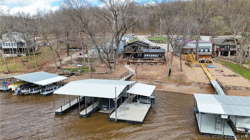 Beautiful 4-bedroom, 2-bath lakefront stone home offering space, comfort, and stunning views of the Lake of the Ozarks. This well-maintained property features a durable metal roof, a large 3-car garage, and an additional 24x18 heated and cooled bonus building with abundant natural light and beautiful lake views—perfect for entertaining, relaxing, or creating a game room or hobby space. Inside, the home offers a spacious upstairs living room and a downstairs rec room, both positioned to capture the lake views and provide plenty of room for family and guests. The updated kitchen adds modern convenience, while the outdoor living spaces are ideal for enjoying the waterfront setting with a large upper deck, lower patio, and an additional oversized deck connected to the bonus building. The private dock is equipped with two slips, jet ski lifts, and a large swim platform, making this a fantastic setup for full-time living or the perfect lake getaway.