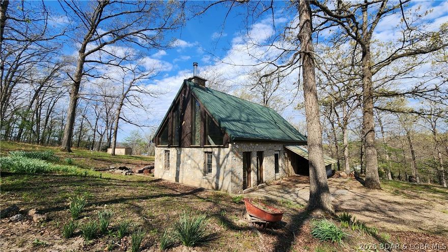 Rustic looking Stone Cabin. Priced to sale quickly. Large Cedar Beams throughout, Wood Ceilings with a Stone Fireplace  Loft Bedroom with French Doors leading to a Private Deck. Bathroom with walk-in Shower and Jetted Tub. All this sits on 2.8 Acres with a 2 car detached garage, storage shed. Seasonal Lake View!