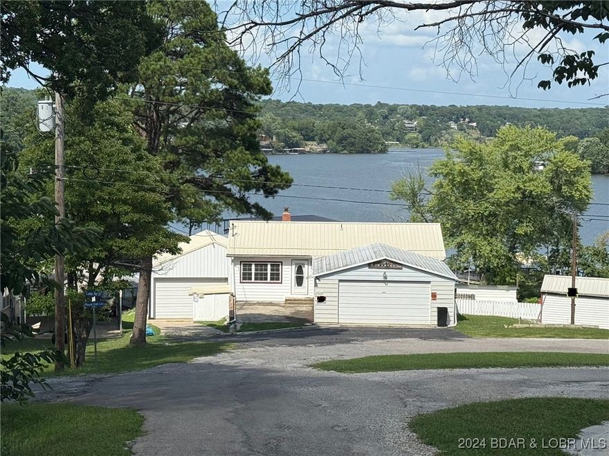 4-bed, 2-bath waterfront home in the Turkey Creek arm of Lake of the Ozarks. Enjoy lake access from your private, 2 slip dock conveniently including electric. The large, 2-car detached garage, and workshop is heated and well insulated providing the ability to comfortably enjoy working on your hobbies all year long. Don't miss out on the beautiful lake views through the new windows throughout the home! The home also boasts spacious living areas and the ease to walkout and enjoy your covered patio and large backyard perfect for outdoor gatherings. With community boat ramp and convenient access to water activities, this property combines comfort and recreation for an idyllic lifestyle.