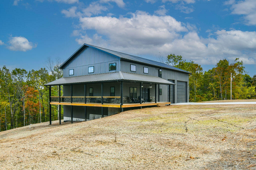 This stunning new construction home located in the beautiful Ozark Mountains offers an open layout, living room with tall ceilings, and a large 2.4 acre lot.  The kitchen boasts solid wood cabinets, granite countertops, a peninsula with seating space and adjoining walk-in pantry and dining area. The home's bedrooms consist of a spacious main suite on the main level with dual vanity, custom walk-in tile shower, soaking tub and walk-in closets.  Bedrooms 2 and 3 are located upstairs along with the loft that's open to the living area below showcasing the custom railing. Upstairs bathroom is large and has additional closet storage.  The generous walkout basement has a large family/media room, bedrooms 4 and 5, a large bathroom with double vanity and multiple storage rooms.  Other features include a 615 square ft covered porch, 200 square ft back patio, 330 square ft lean-to and a large 1178 square foot garage. All this plus  quick and easy access to Table Rock Lake via the neighborhood's community boat launch and dock.