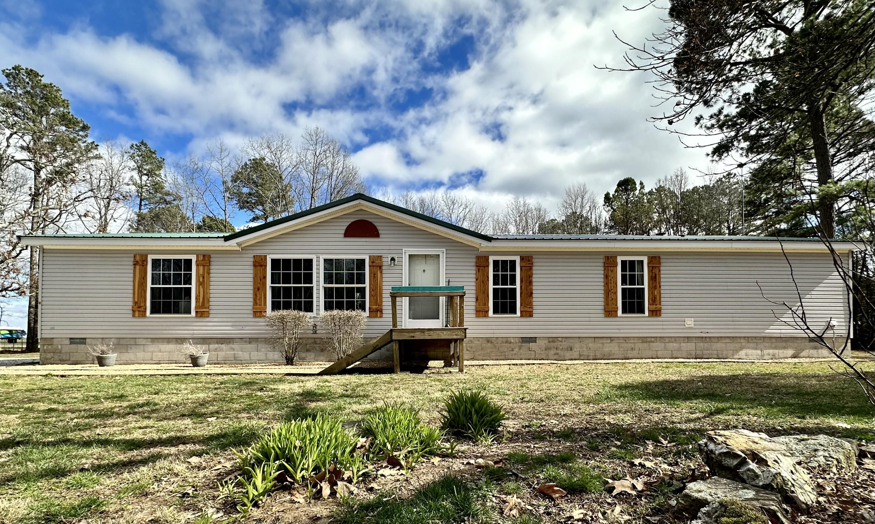 If you are looking for a nice house on a few acres while only minutes from town, then this is the one for you!  Gorgeous tree lined drive leads to a 3 bedroom, 2 bath Hart one owner manufactured home in a peaceful, serene setting at the end of the road.  Located just outside of city limits, this 8 acres m/l offers privacy with no visible neighbors.  2 living areas, a wood burning stone fireplace, large kitchen with oak cabinets and island make this a very comfortable home.  A covered rear deck is ideal for entertaining and less than 2 years old.  Brand new insulated metal roof in August 2022.  Outdoor Hardy wood boiler and newer Rheem ac unit.  30x40 shop with concrete floor with electric and storage shed makes for plenty of space for toys or projects.   Feels like the country, yet minutes from town!  Do not miss out on this home.  Call for your private showing today!