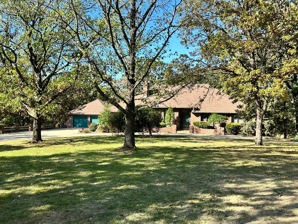 Truly Stunning Home on 26 Secluded Acres- El Dorado Springs, MO. Amazing Home. Amazing Location. Amazing Land & Pond. Sitting just on the edge of town is a rare property with tons to offer. Never run out of space in this 6-bedroom, 3.5-bathroom home with over 4800 sq feet of living space between the main level & the gorgeous walk-out basement. A long, private drive leads to the stunning home (brick on 3 sides), an all-brick detached garage, & a beautiful park-like setting. The home boasts 10' ceilings, hardwood flooring, & attractive beamed ceilings. A balcony overlooks the inviting great room featuring high, vaulted, wood plank ceilings; a grand, stone fireplace (gas); & floor-to-ceiling windows that view the vast backyard & 2.5-acre private lake. The kitchen is large & features granite tops as well as the oversized island/breakfast bar. Other features include stainless & black kitchen appliances, custom solid wood cabinetry, tile flooring, double wall oven, & 5 burner cooktop.  The home offers multiple living & dining areas both upstairs & downstairs and 2 more wood-burning, all-brick fireplaces as well as a wet bar downstairs. Three bedrooms are upstairs & 3 are downstairs, each featuring AT LEAST one large closet. The master features a walk-in closet, 2nd closet, dressing area, jetted tub, & en-suite bathroom with shower. Extras include a large utility room/pantry/ 1/2 bath upstairs; a large mudroom & office/hobby room downstairs; & plenty of extra closet/storage space throughout. All bedrooms & downstairs living area have been upgraded with new carpeting & several new fixtures have been installed since home was originally marketed. A large deck overlooks a peaceful shaded valley (which is the backyard). Just a short walk leads to the deep lake that is stocked with bass, catfish, crappie, & bluegill. The area around the lake is maintained & features 2 mowed peninsulas, a diving board, a floating dock, & a concrete pad with electrical outlets. Call soon!