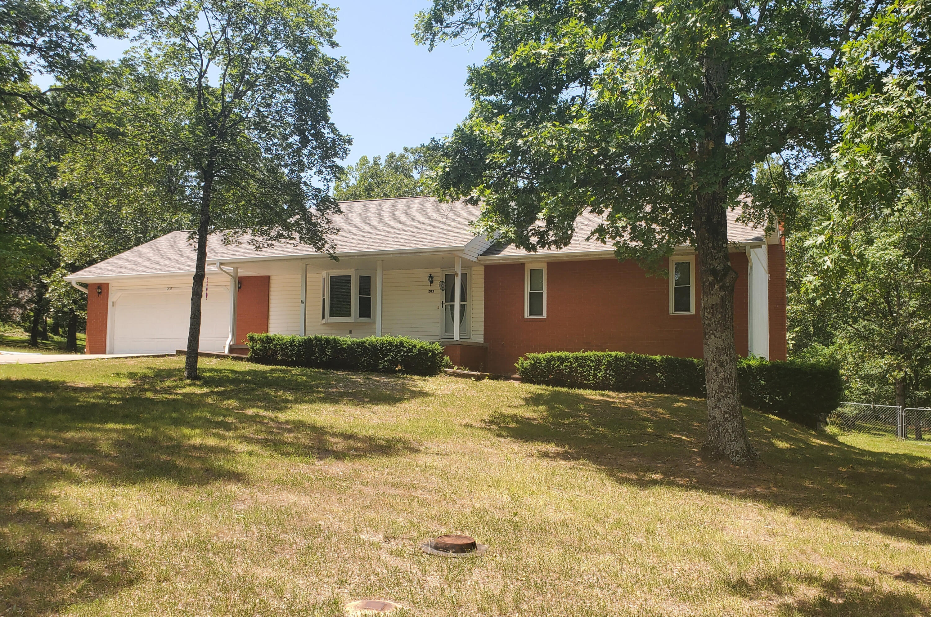 Beautiful 3-bedroom, 2-bathroom house with an oversized 2-car garage in a quiet neighborhood located minutes to all the Branson area has to offer. Once inside you will love the custom hardwood floors, large living room and the bay window helps highlight the natural beauty in the area.  Enjoy your morning coffee on the back deck that is overlooking the peaceful backyard and feels like being farther out in the country. The home has been meticulously maintained and has a new roof that was installed in June 2023. Store your boat or water toys in the John Deere room under the home or use it as a hobby room until your creative heart is content. The home has both a pellet stove and woodburning stove to keep warm in addition to the central heat and air. This home should sell quickly so call and schedule your showing today!