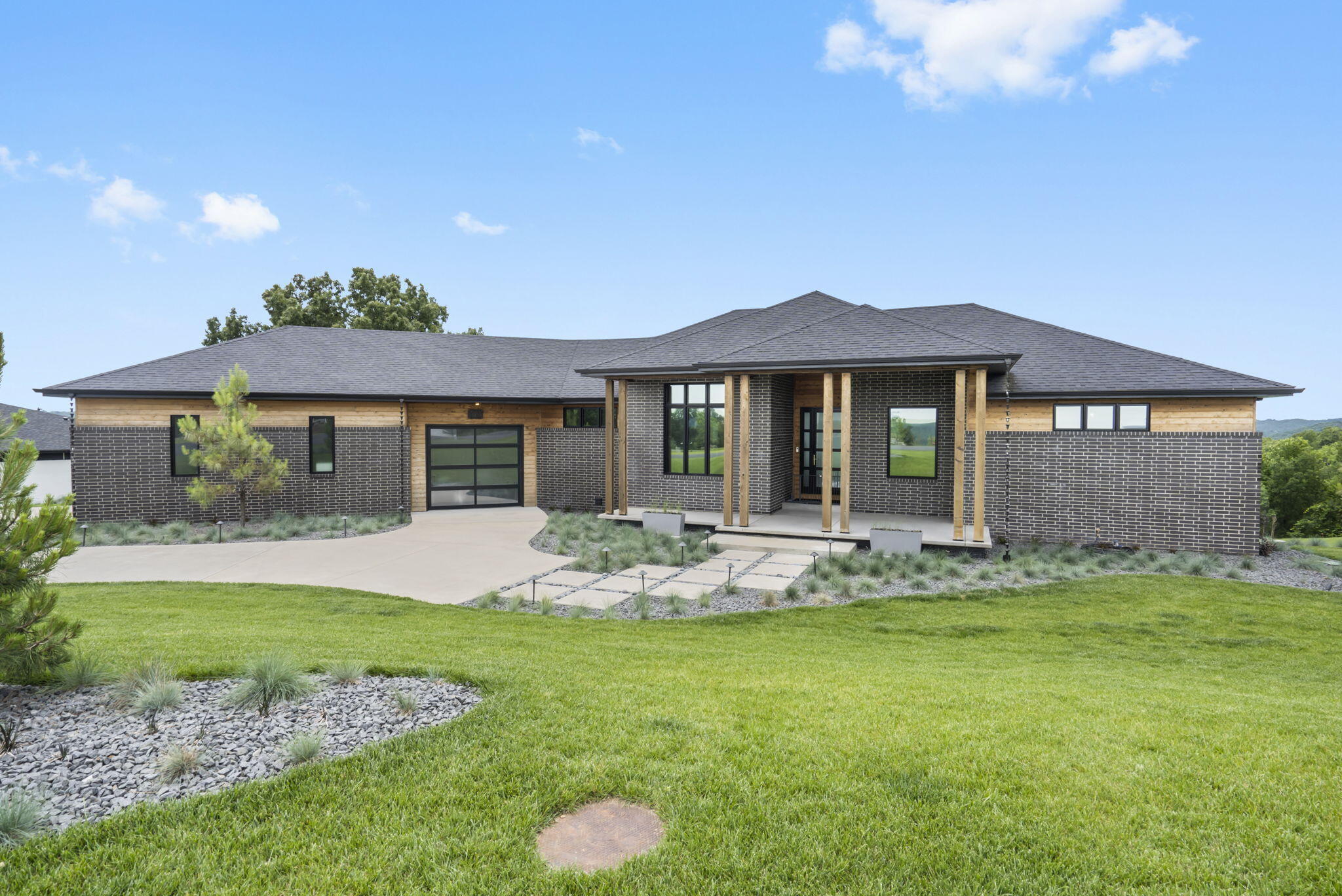 This contemporary gem in Saddlebrooke is a testament to exquisite architectural design. Its open, flowing layout caters to the discerning buyer, with meticulous attention to detail evident throughout. Crafted with materials like brick, steel, and cedar, this home exudes timeless quality. Upon entry, be captivated by the breathtaking panoramic views of the Ozarks from the expansive great room. Large double sliding doors seamlessly connect to a spacious timber-tech deck, perfect for hosting gatherings. The kitchen boasts top-of-the-line fixtures and appliances from brands like Bosch, Meile, and Grohe, complemented by a generous Quartz island and walk-in pantry. Adjacent to the kitchen is a stunning formal dining room adorned with custom windows, while a sizable mudroom and laundry area provide convenient access to the backyard and garage that fits 4 vehicles. The primary suite features a cozy seating area, access to the deck, dual walk-in closets with custom shelving, and a luxurious ensuite with a soaking tub, walk-in tiled shower, double sink vanity w/LED mirrors, water closet, and heated towel rack. Descend to the lower level to discover additional living space, along with the second, third, and fourth (non-conforming) bedrooms, a 150 bottle temperature-controlled wine cellar, wet bar, full bathroom, storage area, and a storm shelter/safe room. The home is equipped with high-efficiency HVAC w/ filter, Sonos sound system (inside & out), water softener, open cell insulation, and tinted windows w/motorized blinds. Outside, the backyard has been meticulously landscaped and new retaining walls added. Property sits on 1.35 acres. Don't miss the chance to own the prestigious 417 Magazine 2020 Home of the Year.