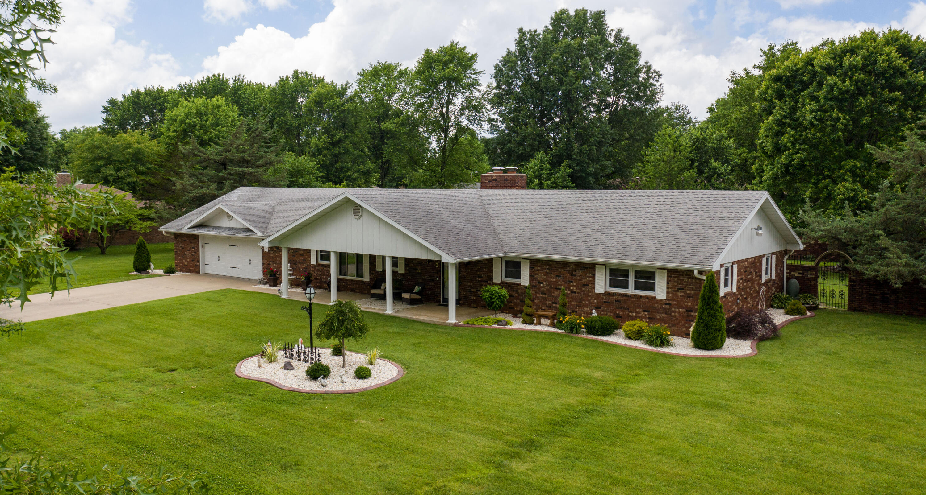 So Impressive!  Quality and charm of 70s  designed ALL BRICK basement home on large double corner lot make this a home to see!  Excellent location within walking distance to Republic Civic Center!   Unique extras to this property are in view right as you drive up onto this corner double lot property. Right away viewing the all brick fencing with iron gates around the back yard and detail given to landscaping ! JUST A RUN THROUGH  OF SOME OF WHAT THIS  HOME OFFERS !  Entering home its so noticeable the attention to quality and care of home.  Incredible kitchen with quartz countertops, large Island giving you lots of counter top space and storage, spacious dining area, new kitchen appliances 2019, polished tile floors,and nice pantry. Gorgeous formal dining area off main living that has stunning full wall China Cabinet. Beautiful main living room with accented with beam ceilings and brick fireplace,with engineered hard wood flooring. This room opens to wonderful second living area sun room with lots of windows for natural light and private back yard views. Home offers-4221 square feet of living space m/l , 3 living areas, 2.5 baths, 4 bedrooms if needed (non confirming 4th bed downstairs) 2 car attached garage with access stairs to basement, large kitchen dining, formal dining area with built in wall china cabinet,solid oak doors,corner, double lot with beautiful landscaping including 2 apple trees and an peach tree and all brick fence around back yard having iron gates ,2 nice sheds in the backyard,Incredible basement space with wet bar,  fireplace, large living space room for game room, video room, work out area, so many possibilities, half bath, plus non conforming 4th bedroom or office space and storage room. Great back yard to enjoy those summer cook outs coming up and old fashioned large covered front porch for that relaxing morning coffee break. Home is all electric. In today's market with all the quality, square feet and yard space  this is one great value!
