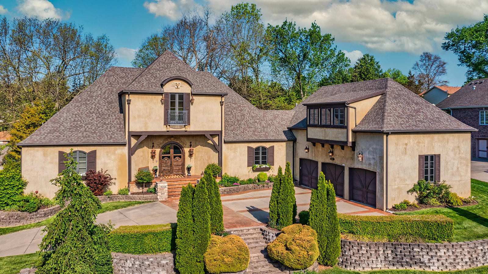 Come enjoy the luxury in this custom built, Mediterranean style home!  The floor plan is very open boasting 12 ft ceilings accented with beautiful solid wood beams.  The contrast of dark beams, decorative reclaimed wood columns, and wide plank wood floors against the newly painted light walls, showcases the special features of this home.  The fireplace mantel & kitchen hood were customized by a local artisan.  The light fixtures in the living & dining are updated from Restoration Hardware.  The library has antique doors & hardware imported from Indonesia, a gas fireplace & built in shelving.  The open plan leads to a fantastic kitchen area, perfect for entertaining!  There are two over sized islands, one with butcher block and bar seating.  The appliances are commercial grade 6 burner GE Monogram stove, GE Profile double oven, warming drawer, ice maker, wine cooler, storage/bar, instant hot water, pot filler, spacious kitchen dining nook with built in seating & cushions, and a mega walk-in pantry.  The kitchen is truly a cooks delight!  The master suite has a vaulted beamed ceiling,new decorative carpet, paint, light fixtures, a seating area for reading, beautiful master bathroom with oversized walk in tile shower, wonderful closet and plantation shutters.  Off the master is a perfect room to work out, office, or sitting area.  It leads to the screened in private lounging area complete with tv area & gas fireplace.  There are 3 bedrooms upstairs, 2 full bathrooms, and a private room behind the shelves in the bathroom.  There is an extra large bonus room as well with great lighting, or new Hunter Douglas room darkening electric window treatments.  Outside are 3 patio spaces, making wonderful outdoor living, plus a heated driveway.   Timberbrook offers a park like setting common space with walking trails, water features, a pool, entertaining area, tennis courts, basketball courts, all in the gated community. HEATED DRIVEWAY This home & neighborhood will not disappoint
