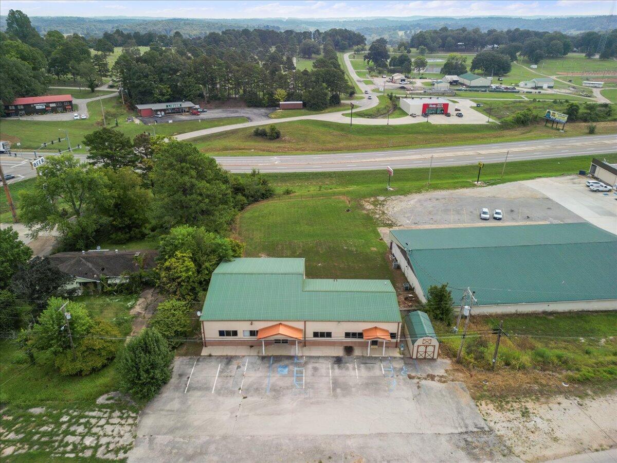 This versatile commercial building, located at 1006 A Nettleton Ave in Thayer, Missouri, presents an incredible opportunity for businesses or investors. Large Office Space: This space welcomes you with a spacious lobby and reception area, complete with a reception window. This space includes 3-4 private offices, a conference room, a kitchen area break room, and a restroom. The high ceilings create an open and professional atmosphere. Additionally, the unfinished basement, which includes a second restroom, offers plenty of space for expansion or secure storage. The building is also equipped with a security system for added peace of mind.Location & Surrounding Area: Situated in Thayer, Missouri, this property enjoys a prime location in Oregon County, near the Missouri-Arkansas border. Thayer is a small, welcoming town with easy access to major transportation routes, making it an ideal location for business. Oregon County's scenic landscapes and thriving local businesses make it a great place to live and work, with a supportive community and access to beautiful outdoor recreation.Additional Opportunity: Also available is a smaller adjoining office space featuring a lobby with a reception window, a large open general room, 2 private offices, a restroom, and a kitchen area break room. Like the larger office, this space also has basement storage, offering flexibility for various business needs. There is also a 0.37-acre vacant lot available located directly behind the main building that further enhances the property's potential. This lot is perfect for additional parking, future building expansion, or development into a separate commercial space, giving you the flexibility to accommodate future business growth.This property, with its flexible office spaces, growth potential, and additional vacant lot, is a fantastic opportunity for businesses or investors looking to establish or expand their presence in Thayer, Missouri.