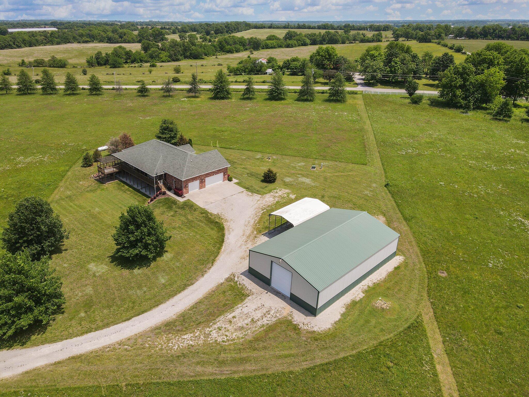 BEAUTIFUL BRICK HOME ON 8.9 GORGEOUS ACRES, WITH STUNNING VIEWS OF SUNSETS! 5 BR 2.5 bath home with a finished walk-out basement on 8.9 acres of stunning prairie land, only minutes from Mt Vernon! Just under 4000 sf of finished living area. You'll love the open floor plan with split bedrooms. Specialty ceilings & many upgraded features throughout. Large living room, formal dining, which are open to a beautiful chef's kitchen with lots of cabinets, island eating bar & a breakfast nook. Nice master suite with his/her walk-in closets, walk-in shower, soaking tub & double sinks.  There is also a  2nd bedroom on the main floor. Large mudroom is located as you enter the home through the garage. Basement features a wet bar, huge rec room with fireplace, full bath, 3 BRs, exercise or office & a mechanical room with storage. Basement would make great in-law quarters. Attached 3 car garage & a 40x64 detached RV garage/workshop with a concrete floor & electricity. RV carport with electricity, water & sewer connections. This home features an alarm system, central vac, bamboo flooring & a storm shelter. There are beautiful views of sunsets off of the back covered deck, overlooking the prairie. Ready for a hot tub, just outside your master bedroom. Amazing views from almost any room in the house! Bring your horses, RVs or other hobbies. Located in the award-winning Mt. Vernon school district. Only minutes to I-44 with easy access to Springfield, Joplin or Monett. Approximately 45 minutes to Stockton or Table Rock Lakes & just over an hour to Branson.