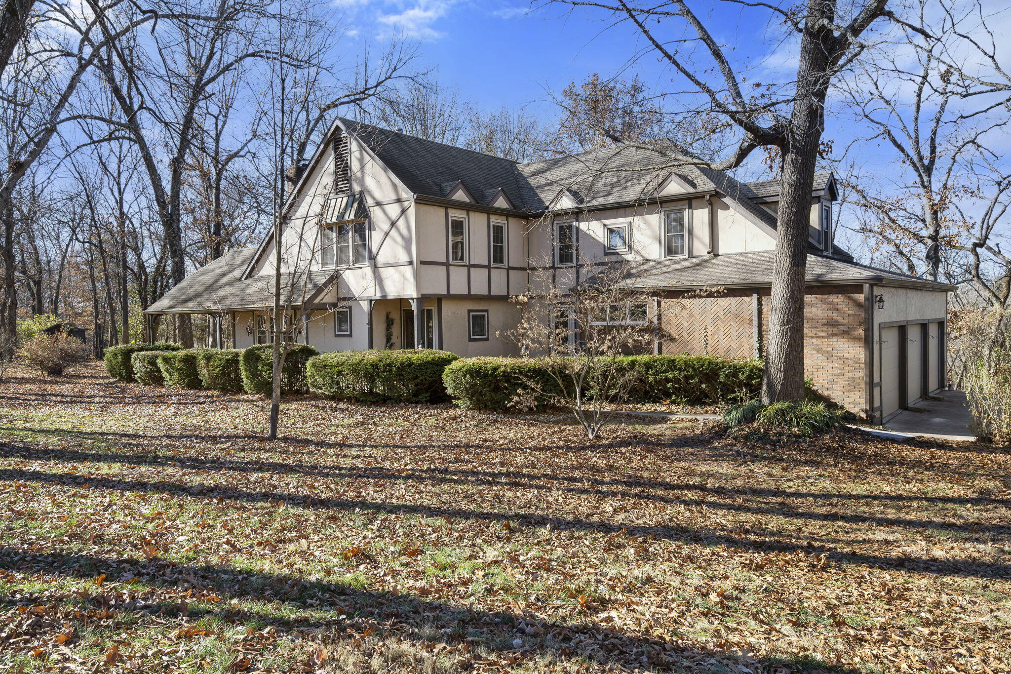 Charming 4 bed, 2 full/2half bath home on over 3 acres in Woodfield Estates.  This Tudor style home features a walkout basement, 2 fireplaces, 2 living rooms, and beautiful stained glass accents throughout.  The main living room has vaulted ceilings and a fireplace with stunning wood mantle.  Off the living room is a sunroom with access to the back deck, a formal dining room, and the kitchen.  The kitchen features ample wood cabinets, a dining space, and a spacious layout.  The walk-out basement features built-ins, an oversized family room, and wood burning fireplace.  Outside, a wooden deck overlooks the sprawling 3+ acres of land on the corner lot property.  Located in Kickapoo School District with quick access to Campbell/James River Fwy.
